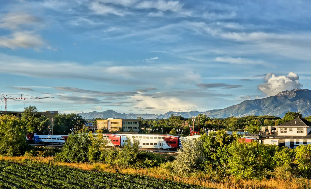 FrontRunner and the historic Layton depot with the Wasatch Mountains behind downtown Layton